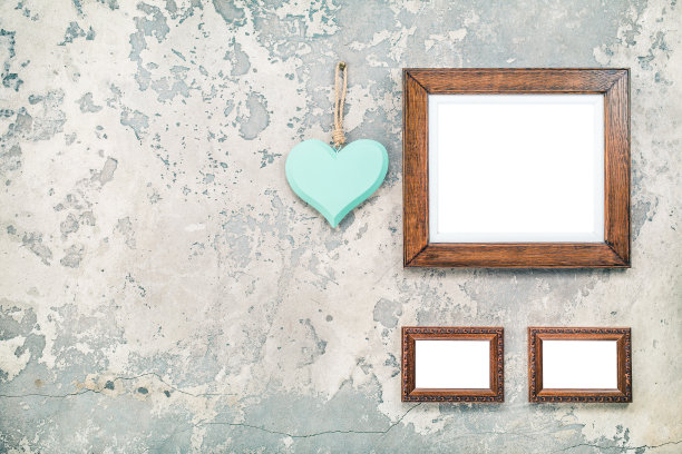 木制的照片或相框，空白和手工情人节爱心挂在复古的老垃圾纹理混凝土墙背景。复古旧风格滤镜照片图片下载