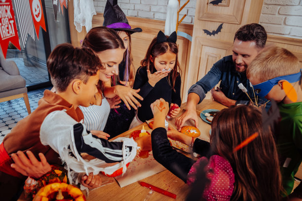 老师们和孩子们互动，孩子们穿着可怕的服装，脸上涂着彩绘图片下载