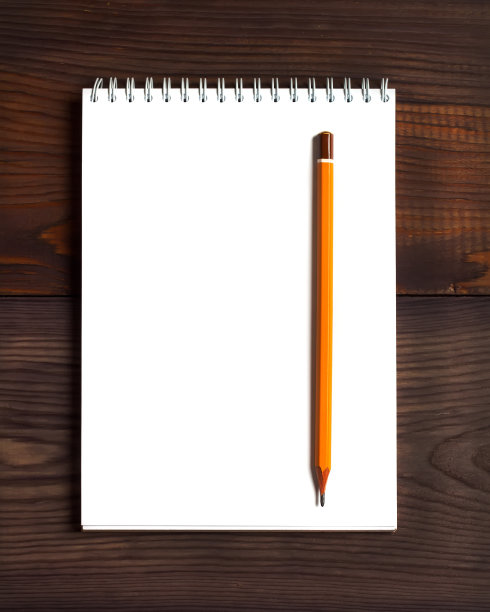 木制背景上的素描本和铅笔。图片下载