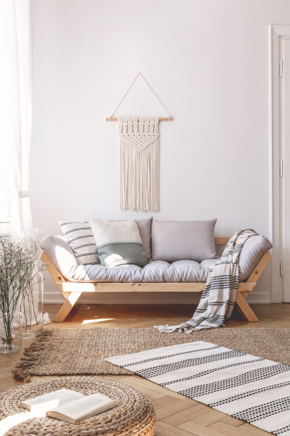 地毯和蒲团在白色的自然客厅内部与装饰上面的长沙发与靠垫。真实的照片图片下载