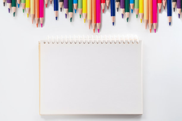笔记本与彩色铅笔在白色桌子上从上面看图片下载