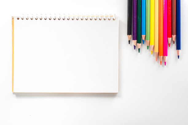 笔记本与彩色铅笔在白色桌子上从上面看图片下载