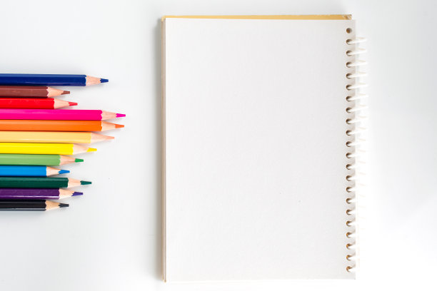 笔记本与彩色铅笔在白色桌子上从上面看图片下载