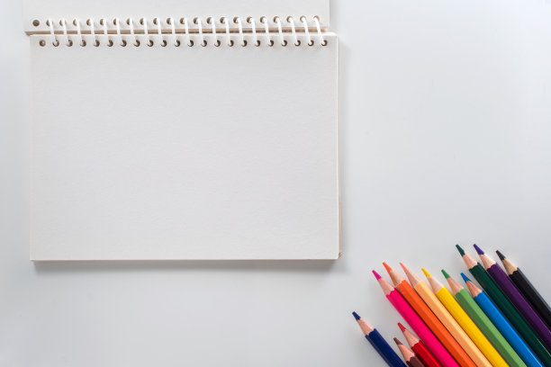 笔记本与彩色铅笔在白色桌子上从上面看图片下载