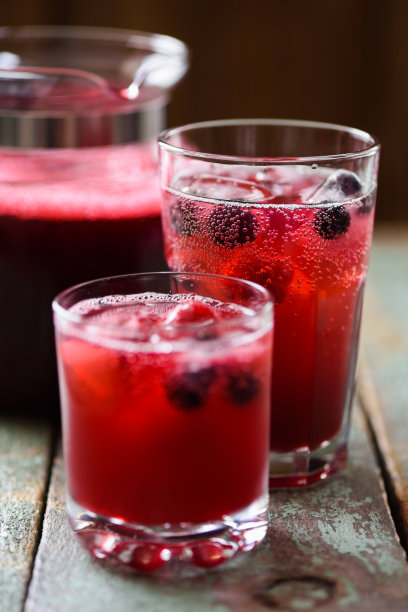 清爽的非酒精饮料。桑格利亚汽酒，樱桃汁和苏打水的冷饮，在蓝色的背景上加冰图片下载