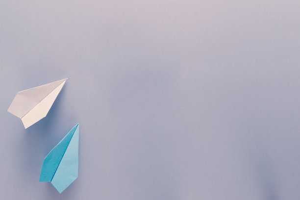 蓝色背景上有两架飞行的纸飞机。回归学校和教育理念。飞机作为旅行和旅游的象征。图片下载