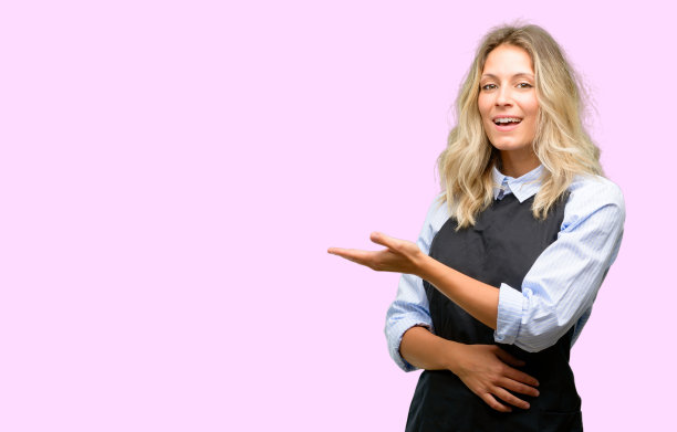 年轻的店主穿着黑色围裙，手里拿着什么东西图片下载