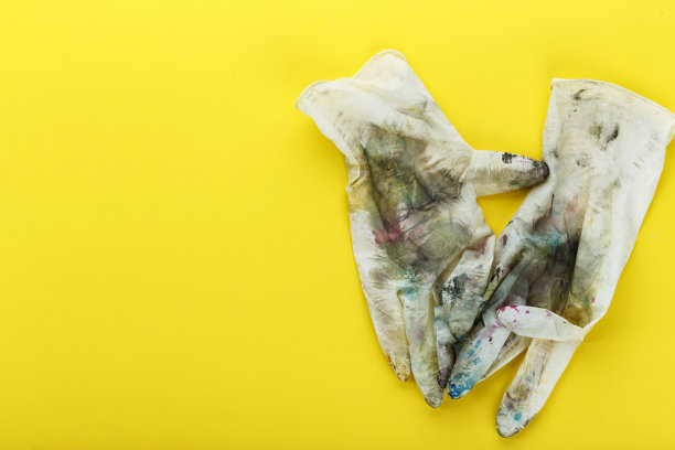 肮脏的橡胶手套上有五颜六色的斑点图片下载