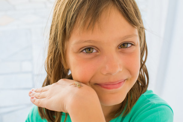 一个漂亮的小女孩挽着一只小蜥蜴摆姿势图片下载