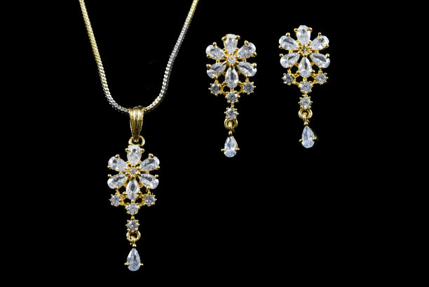 花哨的美国钻石陈吊坠首饰与耳环颈部设置为女性时尚在黑色的背景图片下载
