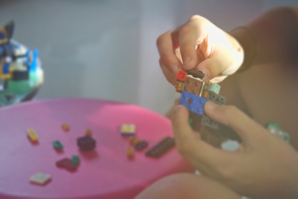 用玩具积木组成的男孩的手，旁边有各种粉红色的桌子。图片下载