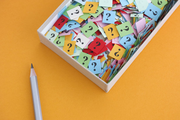 铅笔和问号在一个纸盒黄色的背景图片下载