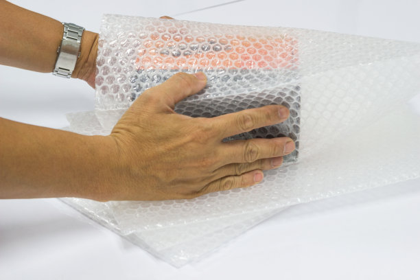 男人手持气泡膜，用于包装和保护易碎产品图片下载