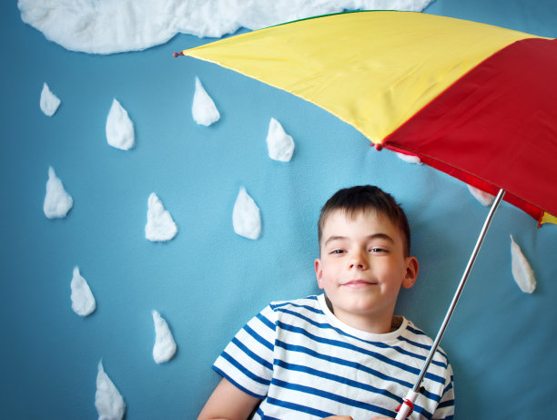 蓝色背景上的小男孩穿着带有水滴形状的外套图片下载