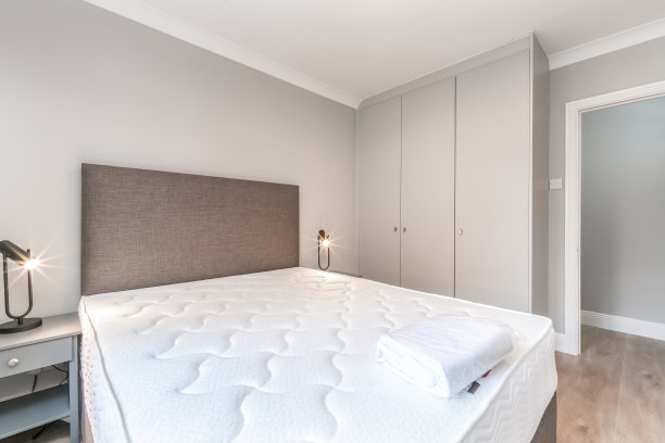 大床在一间卧室里，夜灯在床的一侧图片下载