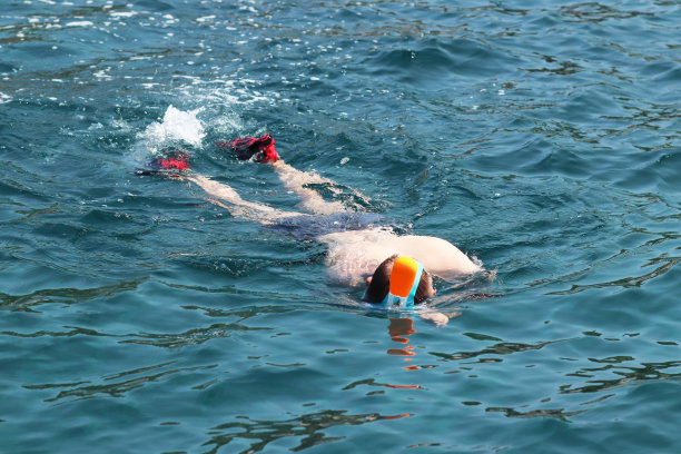 戴潜水镜的男孩在清澈的海水中游泳，水上娱乐欣赏珊瑚环礁风光，享受度假旅游图片下载