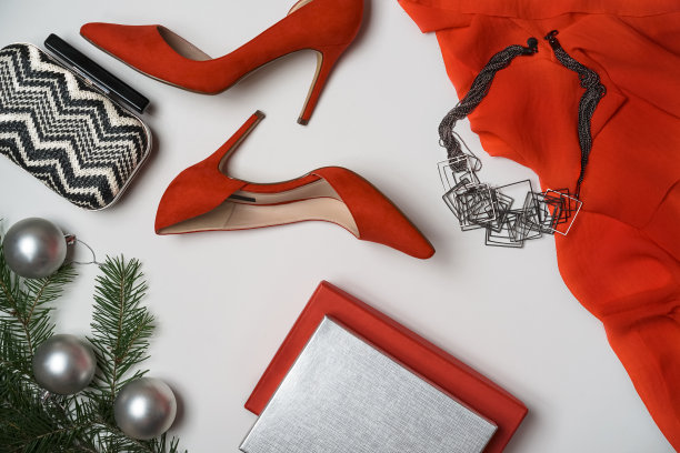平铺到新年和圣诞派对装组成红鞋配件珠宝化妆手包沙漏杉树与球白色的背景。派对约会之夜构思。平铺，拷贝空间图片下载