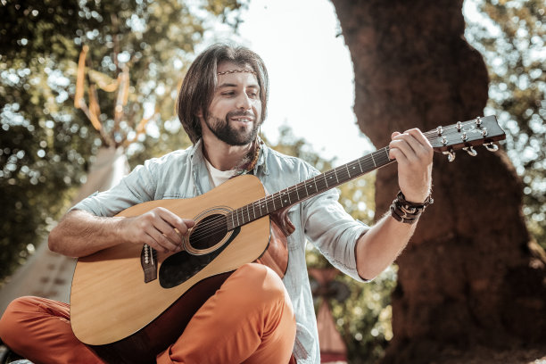 微笑的胡子男人唱着歌，弹着吉他图片下载