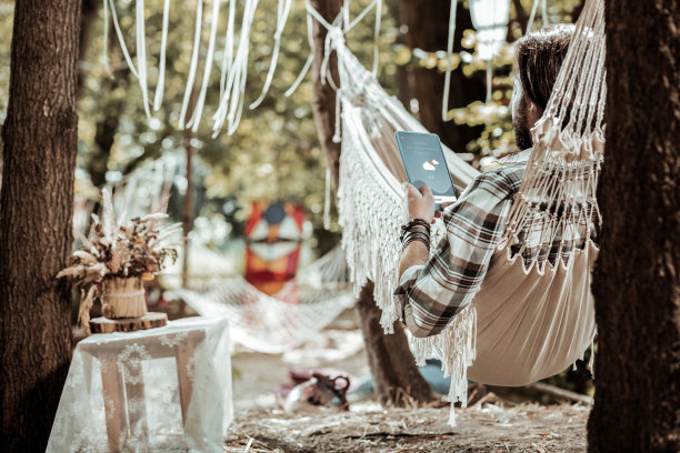 一个年轻人拿着平板电脑看天气预报图片下载