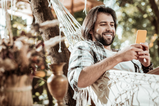 愉快的年轻人正在舒适的吊床上休息图片下载