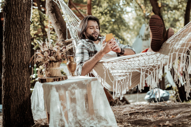 戴着耳机躺在吊床上的帅哥图片下载