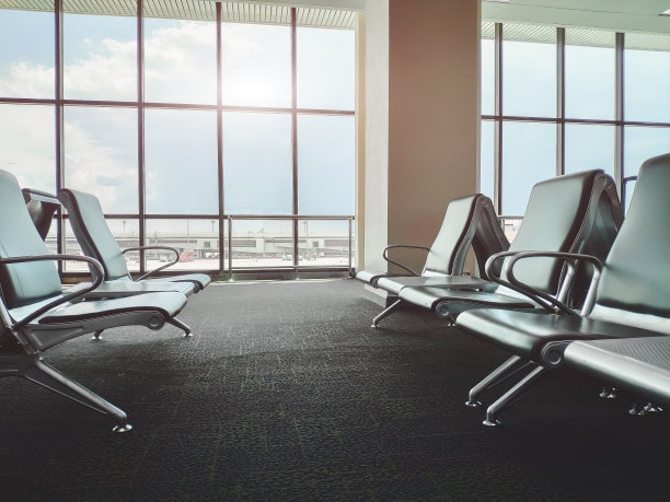 机场候机楼的空长凳。旅客等候区。选择性聚焦和太阳耀斑效应。图片下载