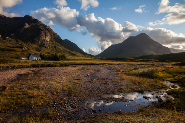 在美丽的落日余晖与低云在溪流中反射的白宫被群山包围图片下载