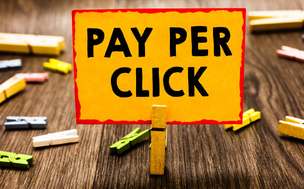 显示按点击支付的概念手写。商业图片展示互联网广告模式搜索引擎营销策略晾衣夹拿着橙色纸笔记晾衣夹木地板。图片下载