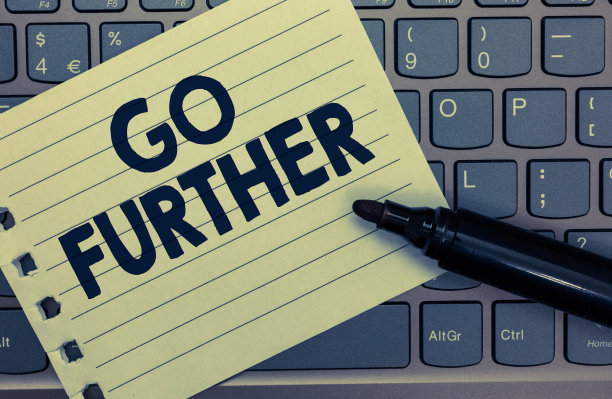 显示Go Further的概念性手写。商业图片展示移动到更大的距离或克服你的限制笔记本纸键盘灵感电脑黑色记号笔。图片下载