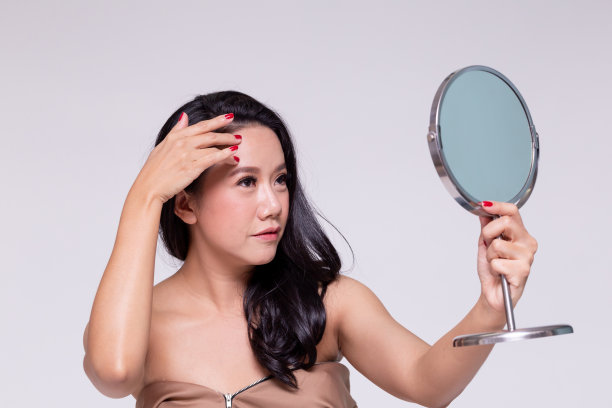 美丽和老化的亚洲女人担心皱纹和美容治疗她的皮肤护理镜。图片下载