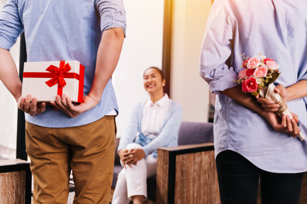 十几岁的儿子和女儿藏一个惊喜的礼物和一束玫瑰，并在她的特殊日子，如母亲节或生日给她。庆祝及节日概念图片下载