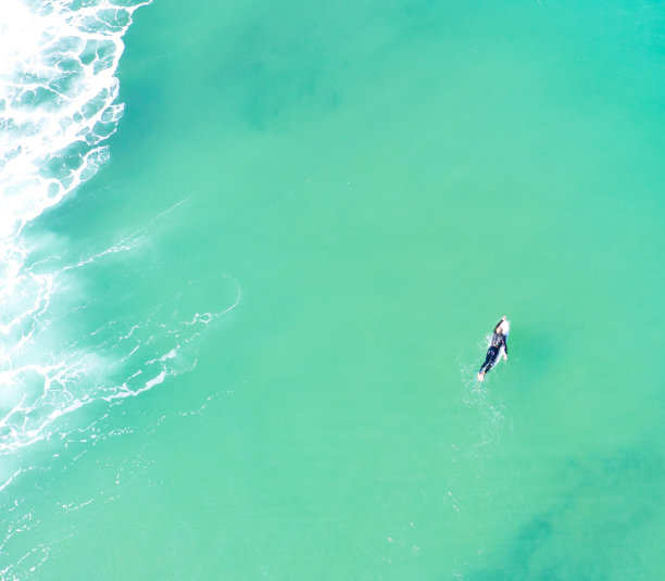 一名男性冲浪者划向大海图片下载