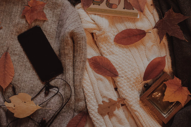 舒适的毛衣上放着带耳机的智能手机图片下载