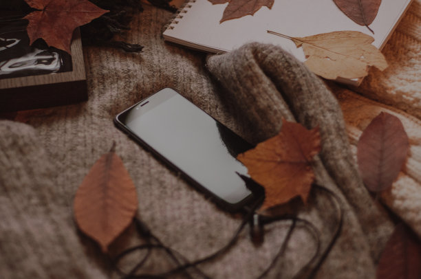 带耳机的手机和香水的秋日毛衣图片下载