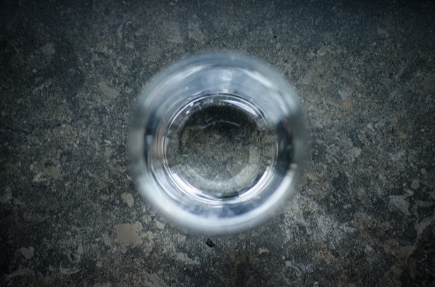 一个浅的镜头，一杯水定位在一个乡村，大理石银行的中心图片下载