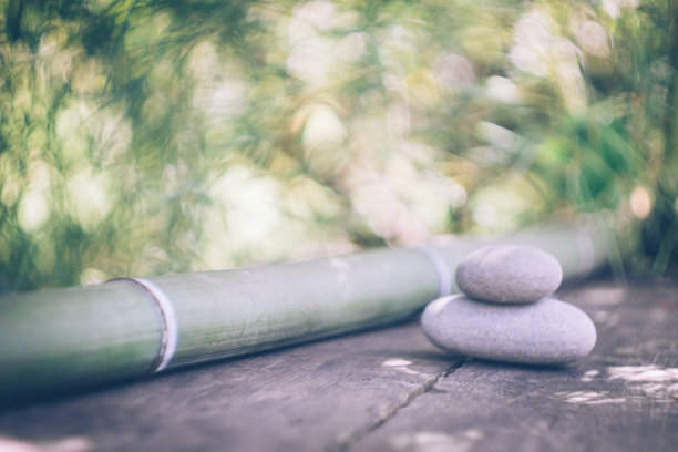 在阳光明媚的日子里，以竹子和石头作为禅宗背景的旧木桌。日本风格。简单，放松，平静，平和的心情图片下载