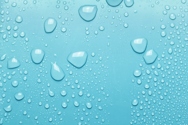水滴在光滑的表面，蓝色的背景图片下载