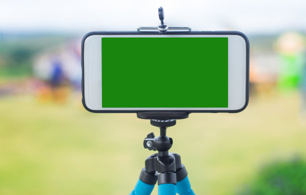 三脚架上的智能手机，背景是天空和云彩图片下载