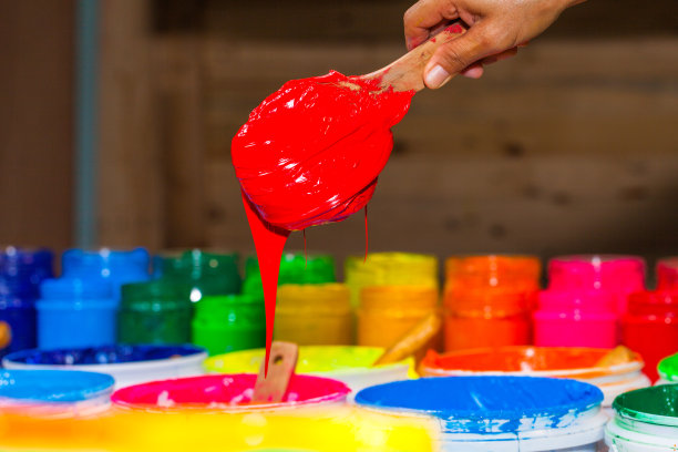 用勺子舀出红色的塑料溶胶油墨图片下载