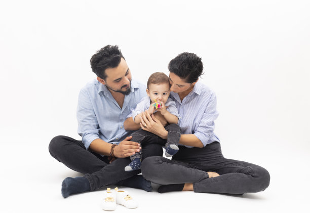 快乐的年轻父亲，母亲和男婴在白色的背景图片下载