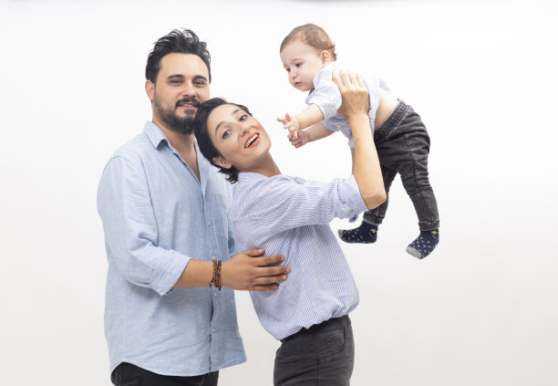 快乐的年轻父亲，母亲和男婴在白色的背景图片下载