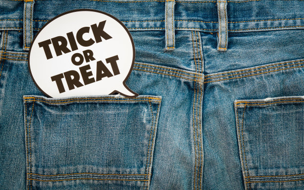 万圣节快乐的一天。时尚背景的概念。顶部视图的Trick or Treat标志上的牛仔牛仔裤。图片下载