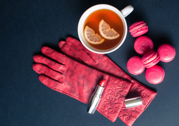 红色的手套和法国马卡龙在黑暗的背景。图片下载