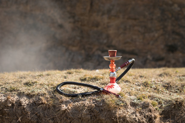 水烟，传统阿拉伯水管，直接日落光，户外照片。山的背景或水烟的剪影在日落的背景。户外。有选择性的重点图片下载