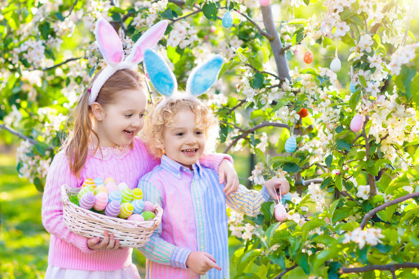 寻找复活节彩蛋。有兔耳朵和篮子的孩子。图片下载