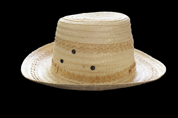 黄色的柳条帽子在黑色的背景图片下载