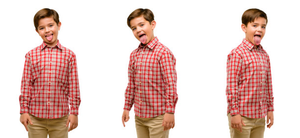 英俊的蹒跚学步的孩子在镜头前伸出绿色的眼睛，表示不服从、抗议和不尊重图片下载