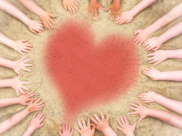 孩子们的手在沙子里，中间有颗心图片下载