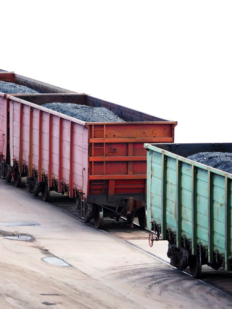 装有煤的火车车厢被隔离在白色的背景上。火车运输黑煤图片下载