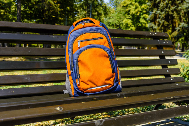 游客背包在城市公园的长椅上图片下载